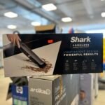Boxed Shark cordless handheld vacuum cleaner on a store shelf, price sticker visible on the box.