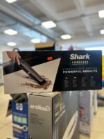Boxed Shark cordless handheld vacuum cleaner on a store shelf, price sticker visible on the box.