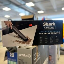 Boxed Shark cordless handheld vacuum cleaner on a store shelf, price sticker visible on the box.