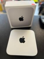 Close-up of a white Apple product box with a black Apple logo on a gray panel, sitting on a dark counter, with a matching card in front.