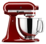 Red KitchenAid Artisan stand mixer with a shiny stainless steel mixing bowl and tilt-head design.