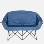 Blue foldable camping sofa with a metal X-frame, viewed from the back with armrests on either side.