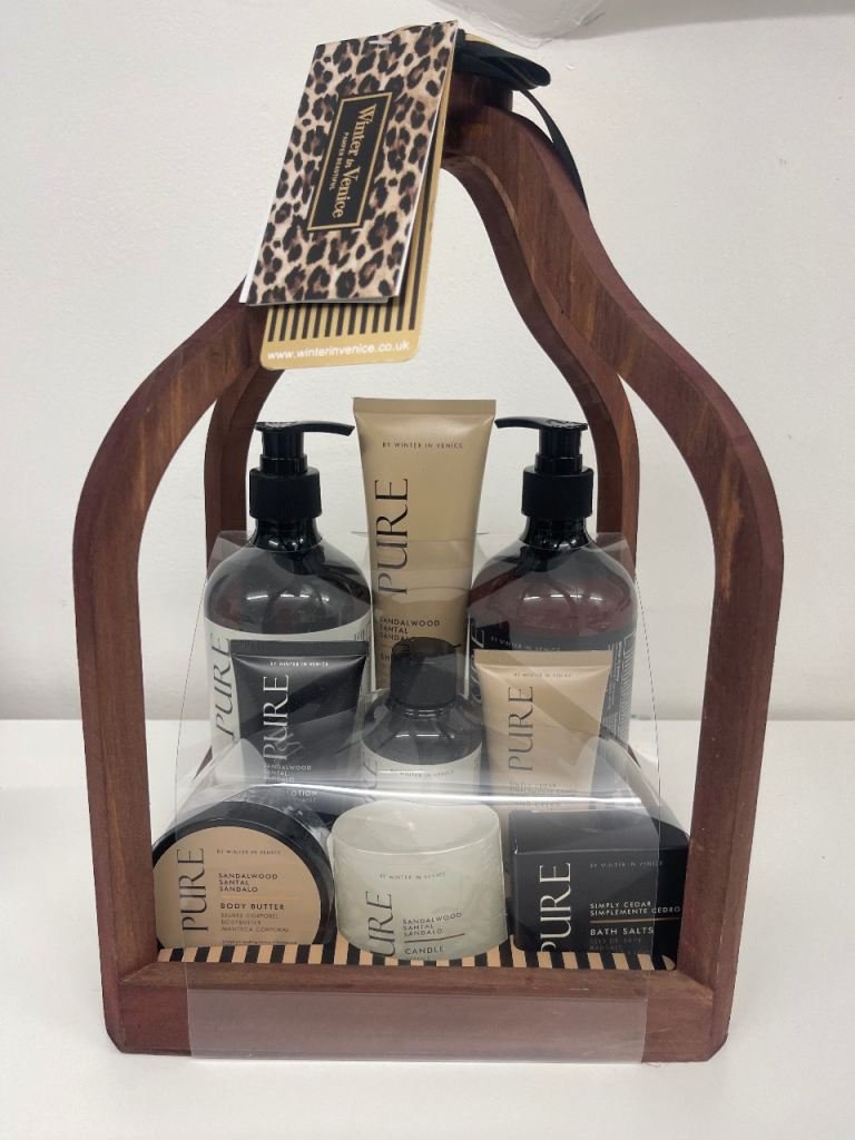 86 - Radau Viska Wooden carrying frame holding a Pure sandalwood body care gift set with pumps, cream tubes, and soaps inside a clear wrap