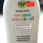 OGX Coconut Miracle Oil Conditioner bottle with gold cap, white container, product name and 'Damage Remedy' label, price sticker visible.