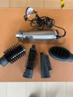 BaByliss corded hair styling wand with multiple interchangeable brush heads laid out on a brown surface.