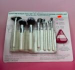 Makeup brush set in a clear plastic case on a pink background, with a light blue header showing 'Signature Makeup Tools Set' text.