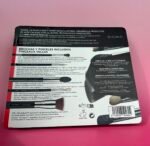 Boxed Sigma makeup brush set on a pink surface, with product text in Spanish and a barcode visible