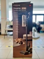 Boxed Dreame Z30 cordless stick vacuum on a table in a bright showroom, with a golden retriever resting at the box’s base.