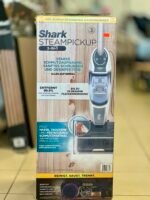 Shark SteamPickup 3-in-1 box on a store shelf showing steam cleaning and disinfection features (German text).