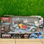 Box for Nikko remote-controlled race car on tiled floor with a grassy background, showing colorful car graphics and branding