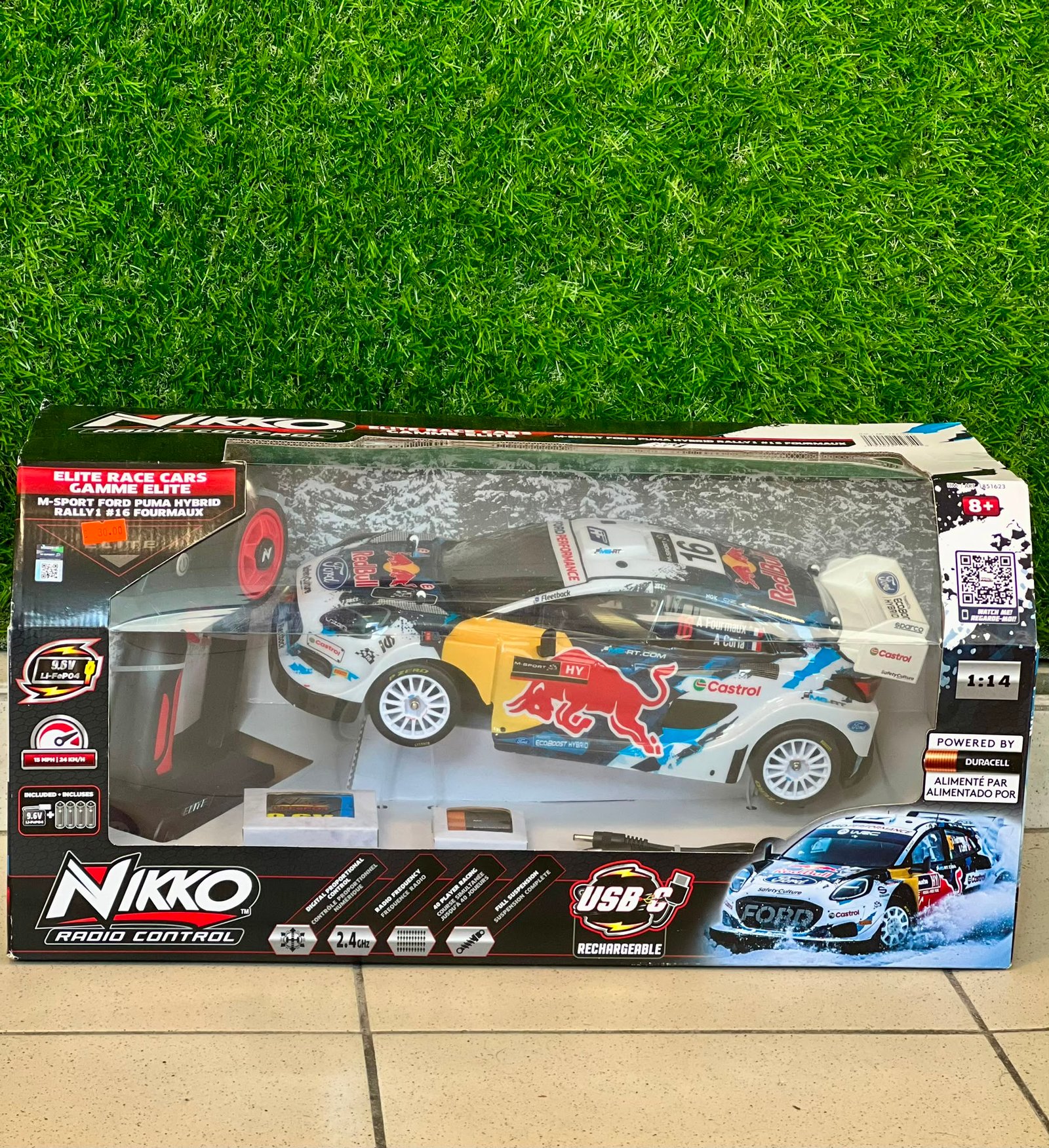 WhatsApp Image 2026-07-20 at 165413 - Radau Viska Box for Nikko remote-controlled race car on tiled floor with a grassy background, showing colorful car graphics and branding