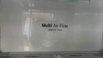 Fridge door with a sign reading 'Multi Air Flow' and 'Total No Frost' on a glossy white surface.