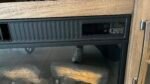 Close-up of a black oven control panel with icons for power, temperature, light, fan, flame, and timer.