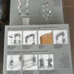 Boxed Artikal Trent shower caddy with chrome rack and shelves, showing installation diagrams and accessories visuals.