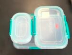 Close-up of two clear plastic containers with turquoise sealing lids and teal latches.
