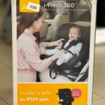 Box showing Joie i-Pivot 360 baby car seat with a smiling mother adjusting her baby in the seat in a car image on the package.