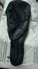 Black, long, rectangular gear case with rounded ends lying on a light surface, zipper along one side.