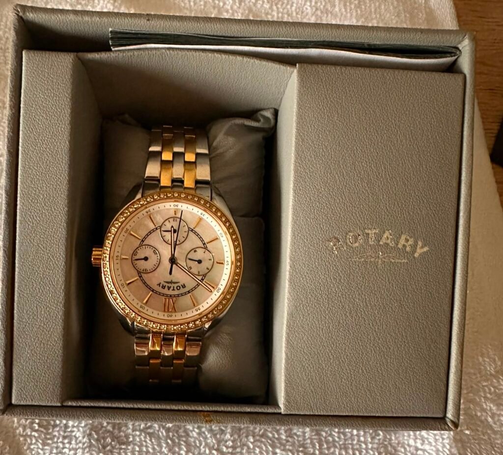 Two-tone gold and silver Rotary wristwatch with a crystal-studded bezel in a gray presentation box