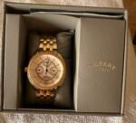 Two-tone gold and silver Rotary wristwatch with a crystal-studded bezel in a gray presentation box