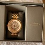 Two-tone gold and silver Rotary wristwatch with a crystal-studded bezel in a gray presentation box