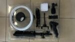 White circular LED ring light with accompanying stand and accessories in a plastic tray, ready for setup.